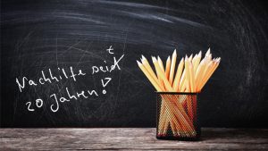 Set of pencils in metal holder on blackboard background